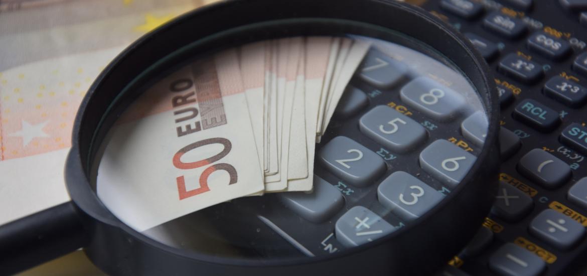 calculator with 50 euros and a magnifying glass