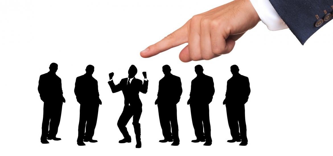 a big finger selecting a guy from a lineup of guys. The guy being picked looks very excited!