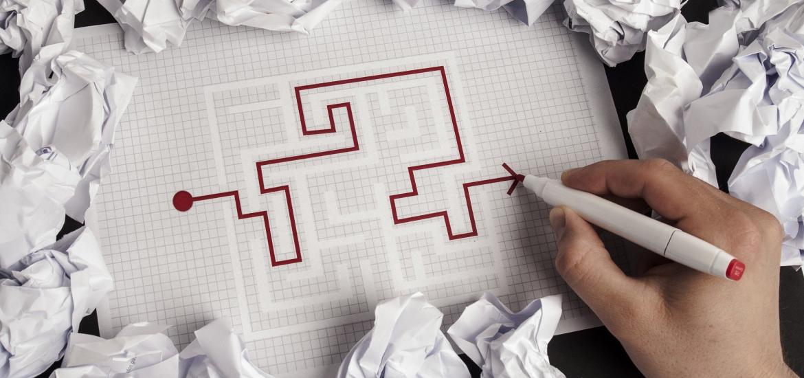 maze on a tablet with crumpled paper around the tablet