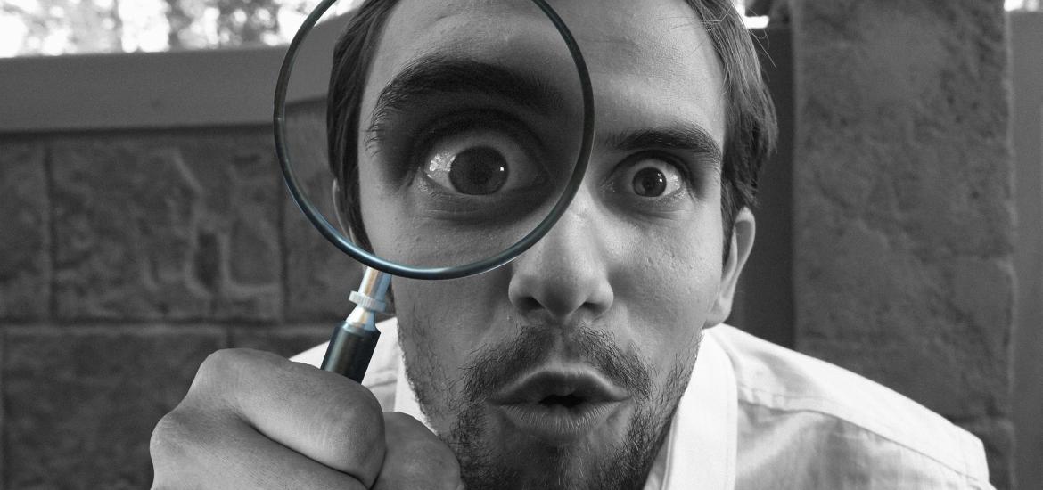 guy looking through a magnifying glass