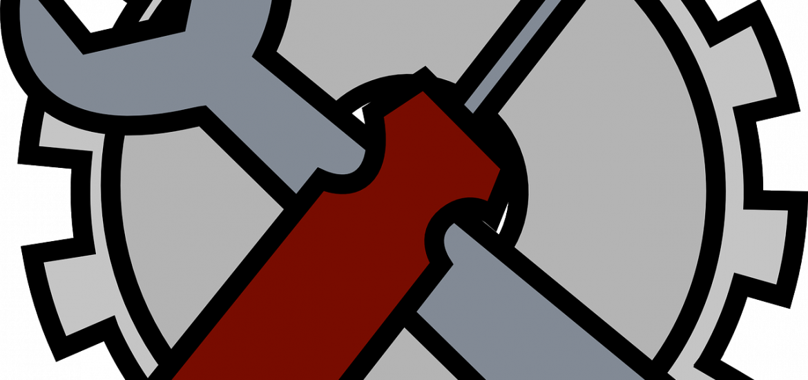 wrench and screwdriver in front of a gear